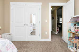 Carpeted bedroom featuring a closet