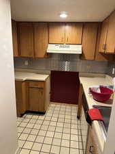 Kitchen featuring backsplash and light tile patterned floors