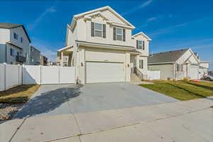 View of front of home with a front yard and a garage