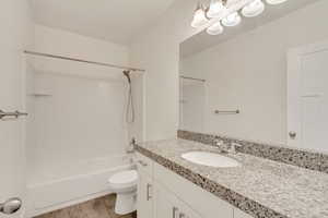 Full bathroom featuring hardwood / wood-style flooring, vanity, toilet, and bathing tub / shower combination