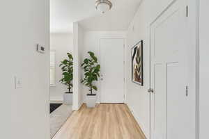 Hallway with light hardwood / wood-style floors