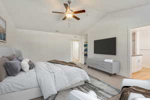 Carpeted bedroom featuring connected bathroom, ceiling fan, and lofted ceiling