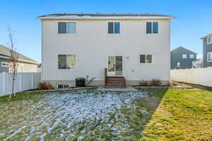 Back of house featuring a yard and central AC unit