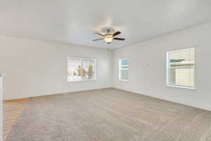 Empty room with hardwood / wood-style floors, ceiling fan, and a healthy amount of sunlight