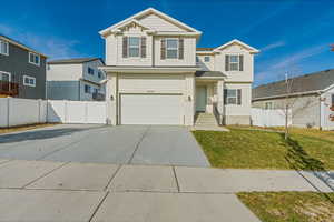 View of front of house with a front yard and a garage