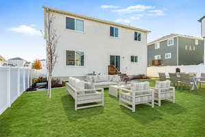 Rear view of house featuring a lawn and an outdoor living space