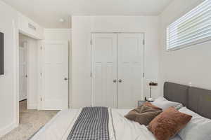 Carpeted bedroom with a closet