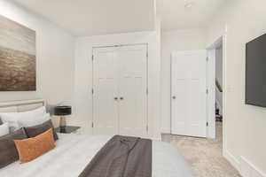 Bedroom with light carpet and a closet