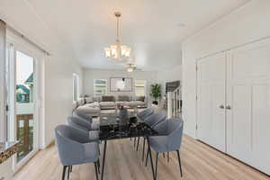 Dining space featuring a wealth of natural light, light hardwood / wood-style flooring, and ceiling fan with notable chandelier