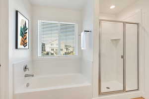 Bathroom featuring shower with separate bathtub