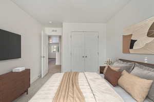 Bedroom featuring light carpet and a closet