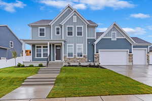 Craftsman-style home featuring a front lawn and a garage