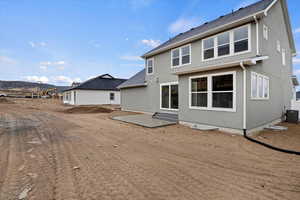 Back of property featuring a mountain view, a patio