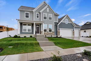 Craftsman-style house with a garage and a front yard