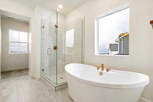 Bathroom with independent shower and bath and a healthy amount of sunlight