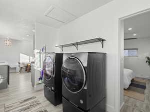 Laundry area featuring washing machine and dryer, plenty of natural light, and light hardwood / wood-style floors