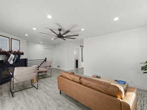 Living room with light hardwood / wood-style floors and ceiling fan