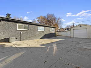 View of property exterior featuring central air condition unit, an outdoor structure, and a garage