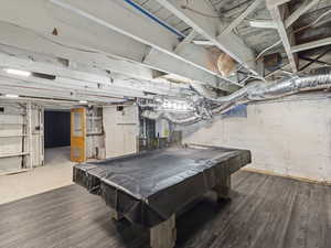 Recreation room featuring tankless water heater, dark wood-type flooring, and pool table