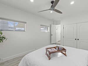 Bedroom with ceiling fan, light wood-type flooring, and a closet