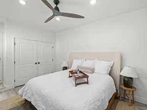 Bedroom with ceiling fan, a closet, and light wood-type flooring