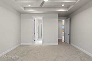 Unfurnished bedroom featuring a raised ceiling, carpet, baseboards, and recessed lighting