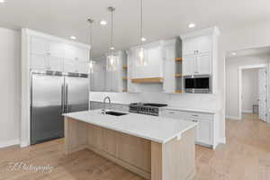 Kitchen featuring built in appliances, open shelves, a sink, baseboards, and recessed lighting