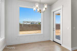 Unfurnished dining area featuring a chandelier and wood finished floors