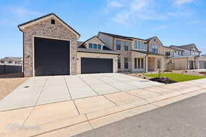 View of front facade with a garage, concrete driveway, brick siding, a tiled roof, and a residential view
