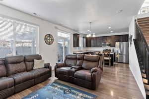 Living room with hardwood / wood-style floors and an inviting chandelier