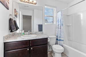 Full bathroom with tile patterned flooring, vanity, shower / bath combination with curtain, and toilet