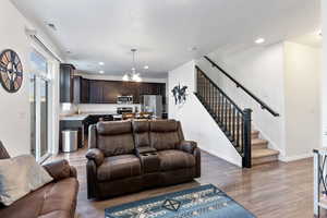 Living room with a chandelier, wood-type flooring, and sink