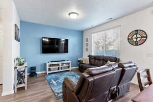 Living room featuring hardwood / wood-style floors and a textured ceiling