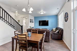 Dining space with a notable chandelier and wood-type flooring