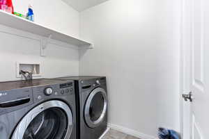 Washroom featuring light tile patterned floors and washing machine and dryer