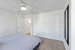 Carpeted bedroom featuring ceiling fan