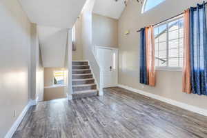 Interior space featuring plenty of natural light, wood-type flooring, and high vaulted ceiling