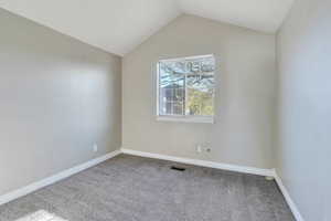 Spare room with lofted ceiling and carpet floors