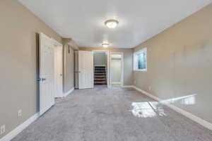 Unfurnished bedroom with light colored carpet, a spacious closet, and a closet