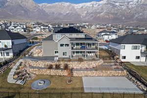 Back of house with a mountain view and a balcony