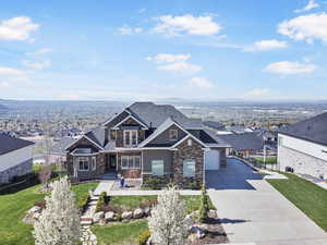 Craftsman inspired home featuring a garage and a front lawn