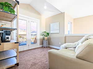 Sitting room featuring carpet floors and vaulted ceiling