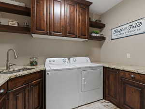 Laundry room featuring cabinets, sink, and washer and dryer