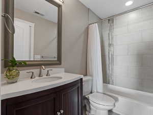 Full bathroom with vanity, toilet, and shower / bathtub combination with curtain