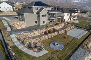 Rear view of property featuring a fire pit, a patio area, and a balcony