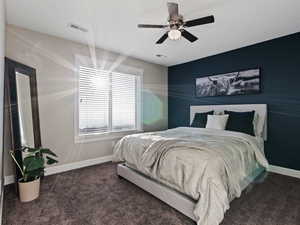 Bedroom with dark colored carpet and ceiling fan