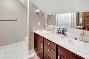 Bathroom featuring vanity, a textured ceiling, and toilet