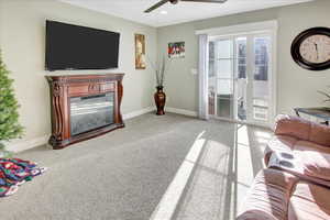 Carpeted living room featuring ceiling fan