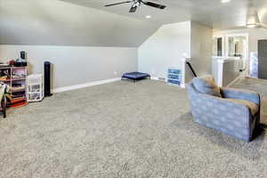 Sitting room featuring carpet flooring, vaulted ceiling, and ceiling fan