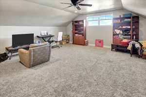 Interior space with a textured ceiling, ceiling fan, and vaulted ceiling